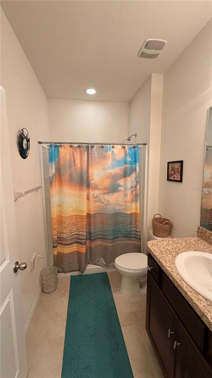 A bathroom features a sunset-themed shower curtain, a toilet, and a dark wood vanity — 6403 DEVESTA LOOP, PALMETTO, FL