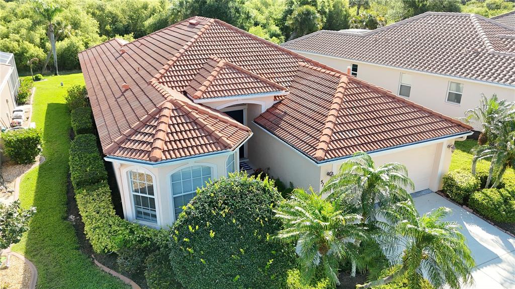 An aerial view of a single-story house with a brown tile roof and palm trees — 5174 PINE SHADOW LANE, NORTH PORT, FL