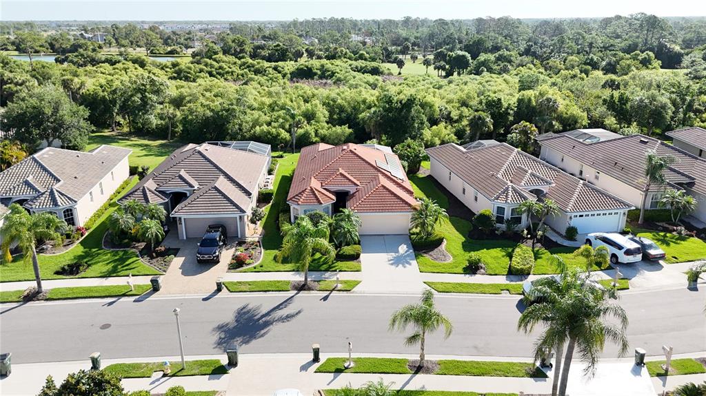 An aerial view shows a row of suburban houses with tile roofs and manicured lawns — 5174 PINE SHADOW LANE, NORTH PORT, FL