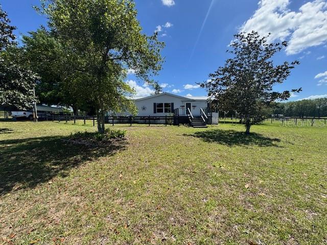 A single-story house with a front porch sits on a large, grassy lot with trees — 19231 NW HIGHWAY 335, WILLISTON, FL