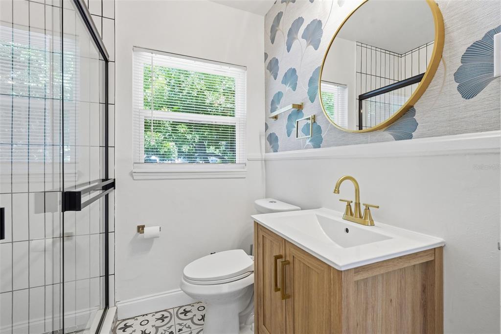 A bedroom features a white metal bed frame, wood-look tile floors, and a ceiling fan — 2855 VALENCIA WAY S, ST PETERSBURG, FL