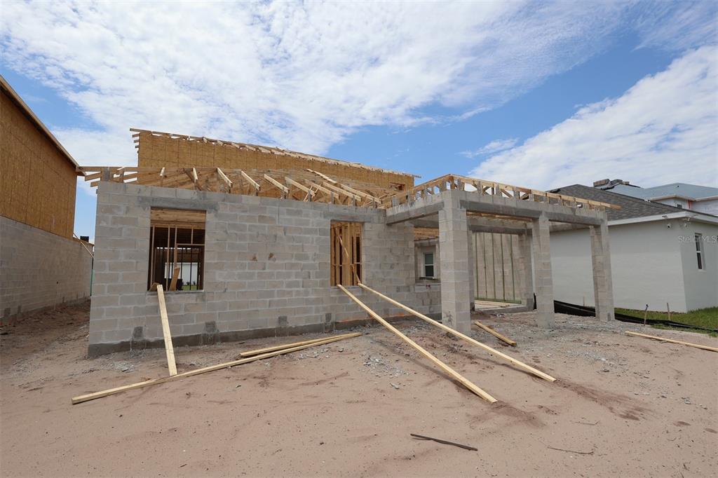 A concrete block house under construction with exposed wooden roof trusses and framing — 6777 YELLOW WARBLER BEND, ST CLOUD, FL