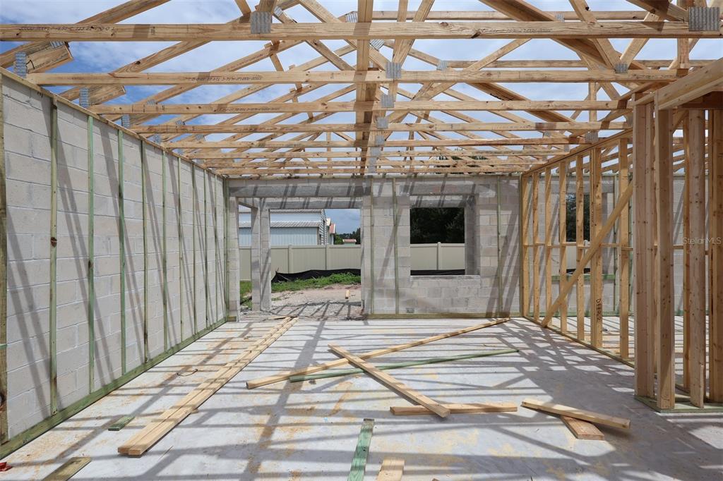 An interior view of a house under construction with concrete block walls and wooden trusses — 6777 YELLOW WARBLER BEND, ST CLOUD, FL