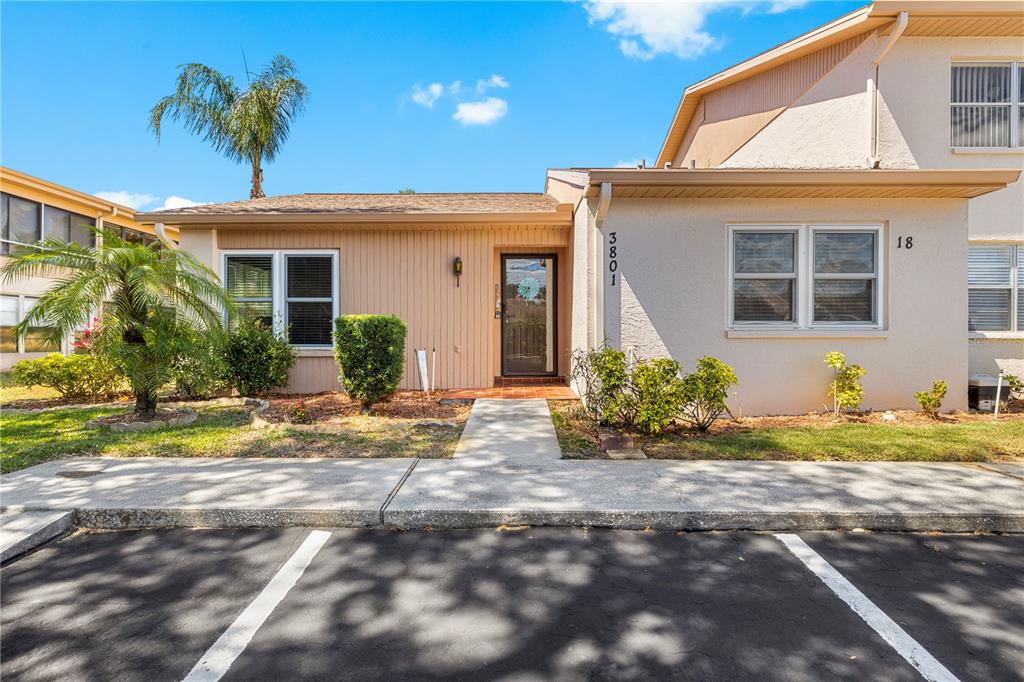 A one-story residential building with tan siding, a front door, and a paved parking area — 3801 SAILMAKER LANE, HOLIDAY, FL