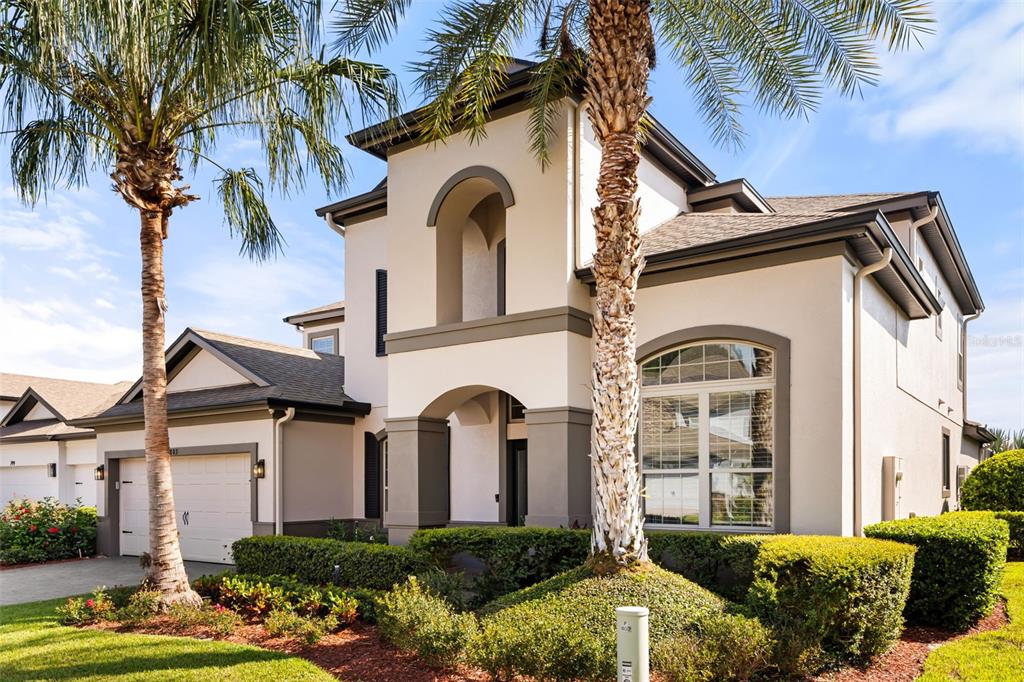 A two-story stucco house with a garage, arched entryway, and palm trees in the front — 803 SHERBOURNE CIR, LAKE MARY, FL
