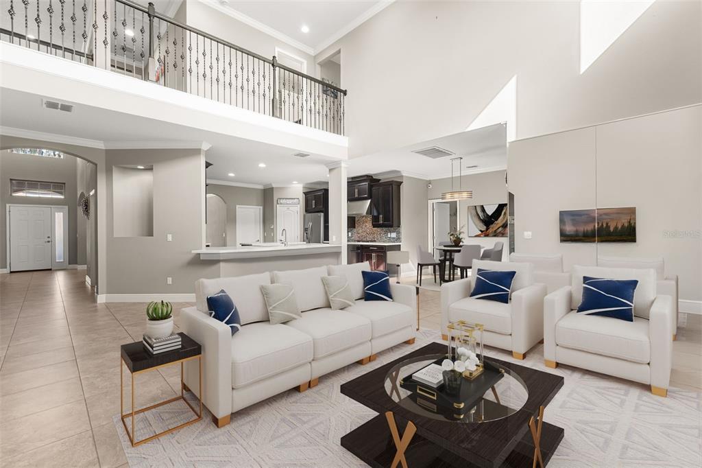 A spacious living room with high ceilings, neutral furniture, and an open-concept kitchen — 803 SHERBOURNE CIR, LAKE MARY, FL
