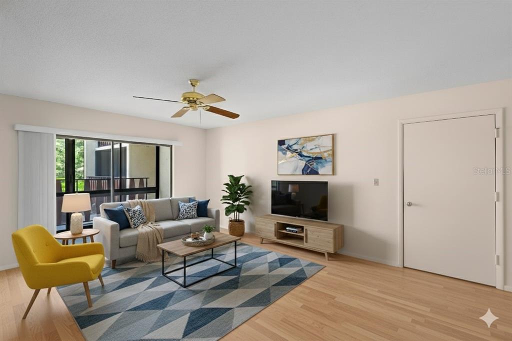 This is a living room with a gray sofa, yellow armchair, and a geometric area rug — 72 BOUNDARY BOULEVARD UNIT 226, ROTONDA WEST, FL