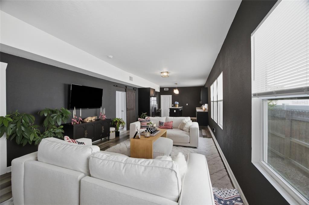 A living room features dark gray walls, white sofas, and a wood coffee table — 2132 W BEACH STREET, TAMPA, FL