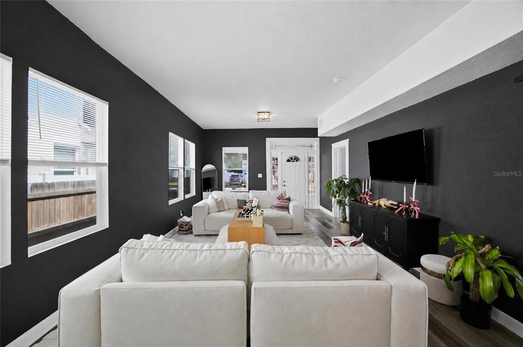 A living room features dark gray walls, white sofas, and a black media console — 2132 W BEACH STREET, TAMPA, FL