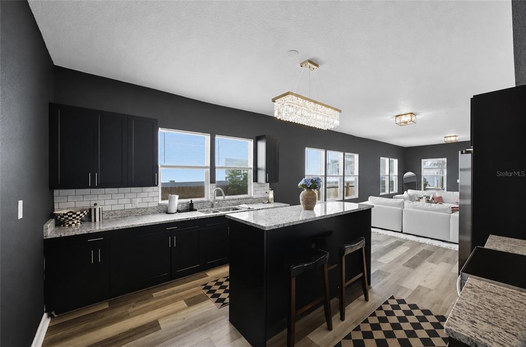 A kitchen with black cabinets, granite countertops, and a white subway tile backsplash — 2132 W BEACH STREET, TAMPA, FL