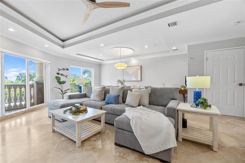 A living room features a gray sectional sofa, a white coffee table, and tile flooring — 604 GULF BOULEVARD UNIT 207, INDIAN ROCKS BEACH, FL