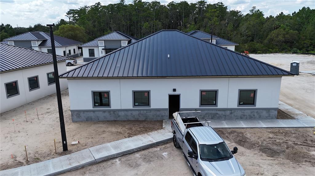 An aerial view shows a construction site with several finished buildings and one structure under construction — 75 EXCHANGE LOOP LOOP UNIT 8, PALM COAST, FL