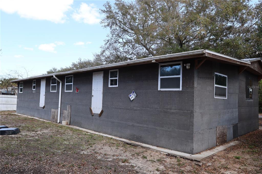 The exterior of a single-story house features gray foam board insulation panels and multiple windows — 6991 ASH DRIVE, COCOA, FL