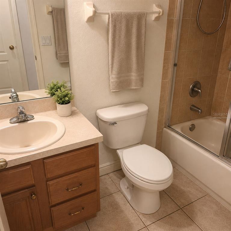A bathroom features a wooden vanity, a white toilet, and a shower-tub combination — 1715 9TH AVENUE, DELAND, FL