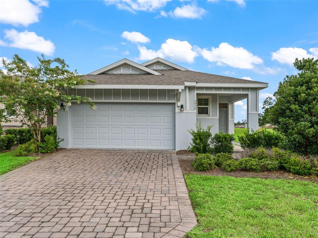 A single-story house with a light gray exterior, a two-car garage, and a paved driveway — 5478 NW 46TH LANE RD, OCALA, FL
