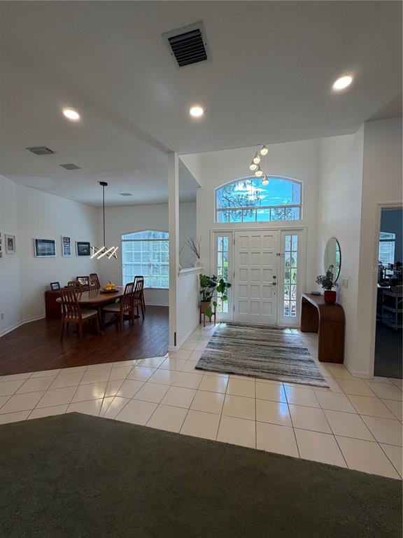 A living room features a red sectional sofa, a gray sofa, and a large sliding door — 2435 SWEETWATER COUNTRY CLUB PLACE DRIVE, APOPKA, FL