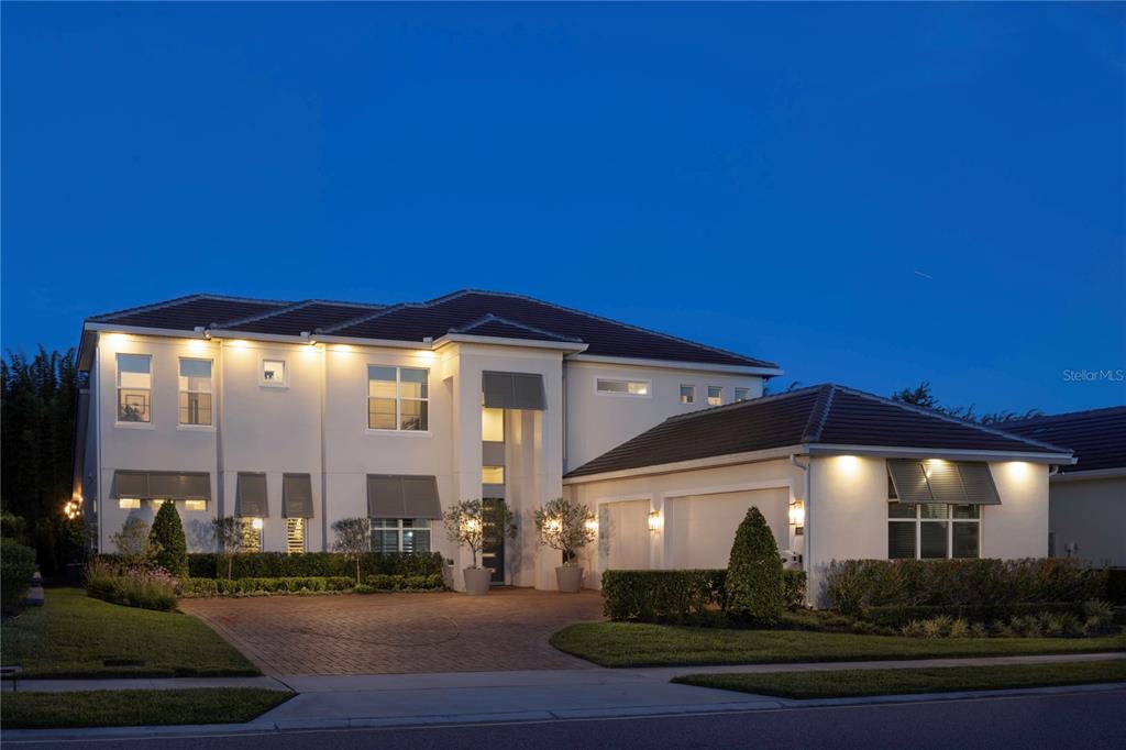 A two-story house exterior features a swimming pool, covered patio, and landscaped backyard at dusk — 1659 CANYON OAK WAY, SANFORD, FL