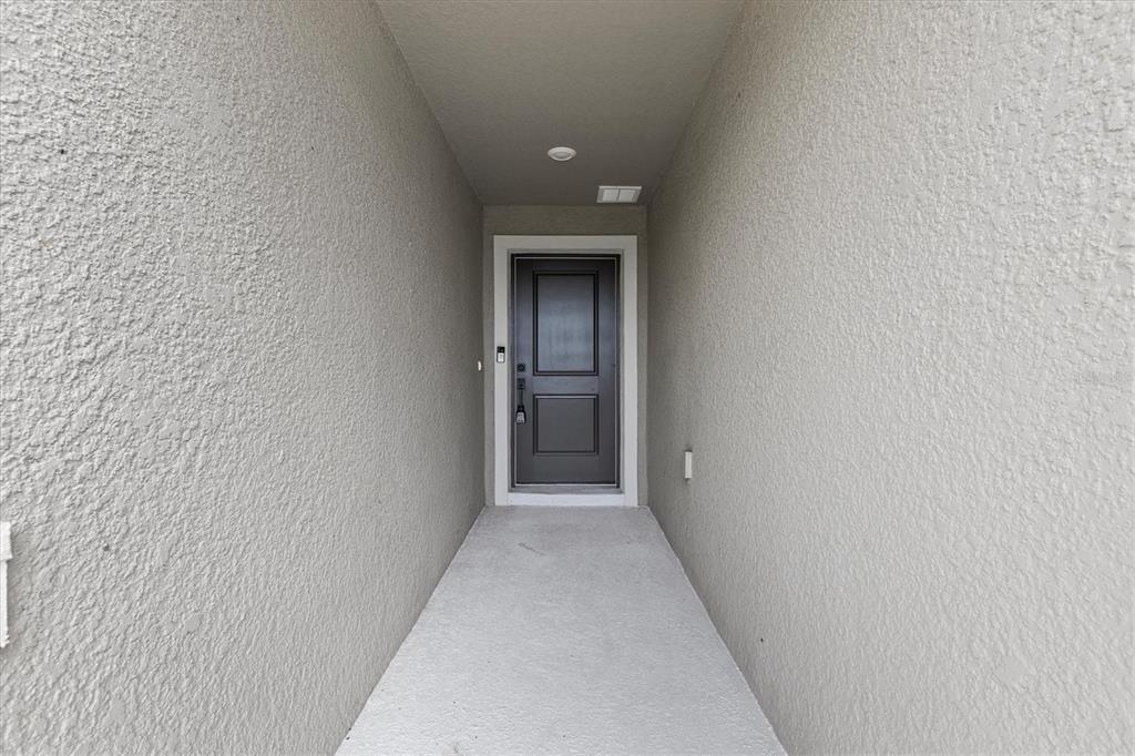 A room with light wood flooring, a desk, side tables, and a sliding glass door — 9972 MESIC WOODS AVENUE, SEFFNER, FL