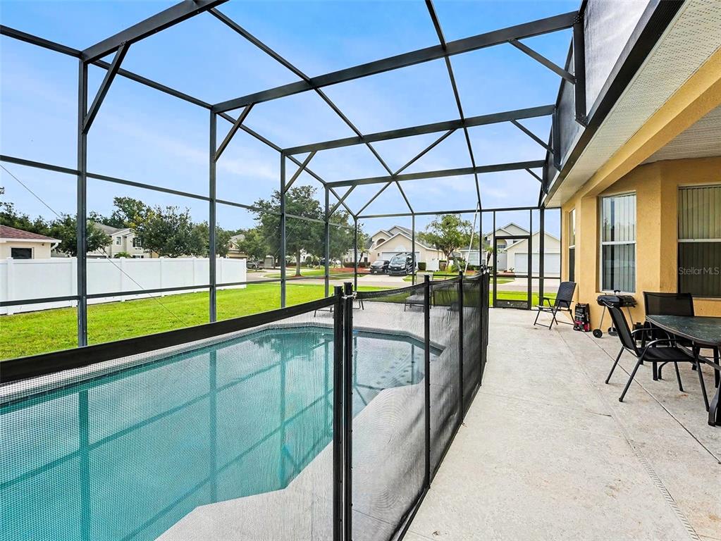 A two-story suburban house with a tan stucco exterior, a two-car garage, and palm trees — 4701 RUBY RED LANE, KISSIMMEE, FL