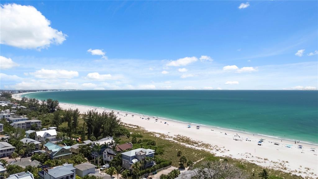 A backyard features a grassy lawn, a storage shed, two utility bins, and a white fence — 306 PALM AVENUE, ANNA MARIA, FL