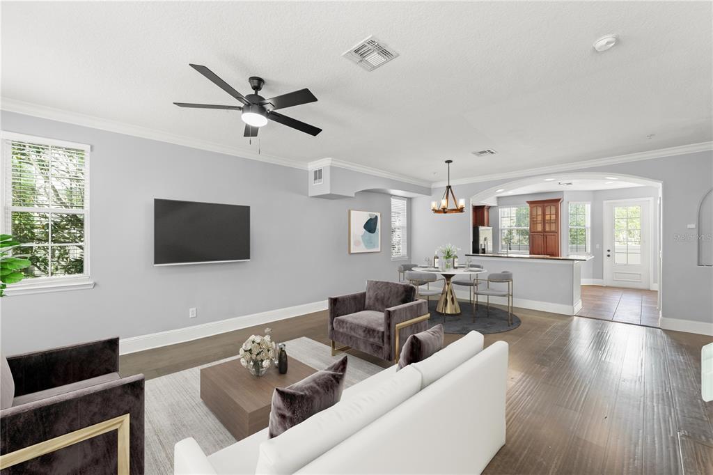 A living room and dining area with hardwood floors, a ceiling fan, and a television — 1563 COMMON WAY ROAD, ORLANDO, FL