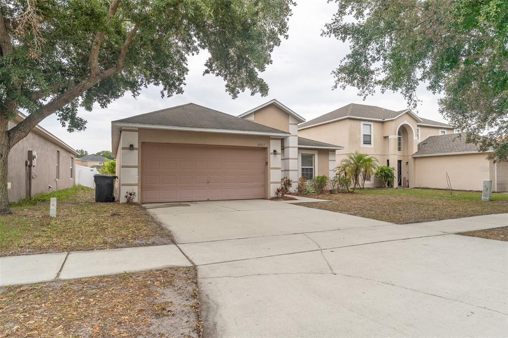 A view of an open-concept living area with wood-look flooring and a kitchen island — 10917 BANYAN WOOD WAY, RIVERVIEW, FL