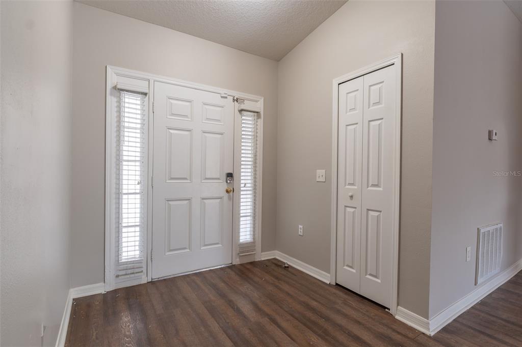 An empty room with gray carpet, light-colored walls, and an arched doorway leading to tile — 10917 BANYAN WOOD WAY, RIVERVIEW, FL