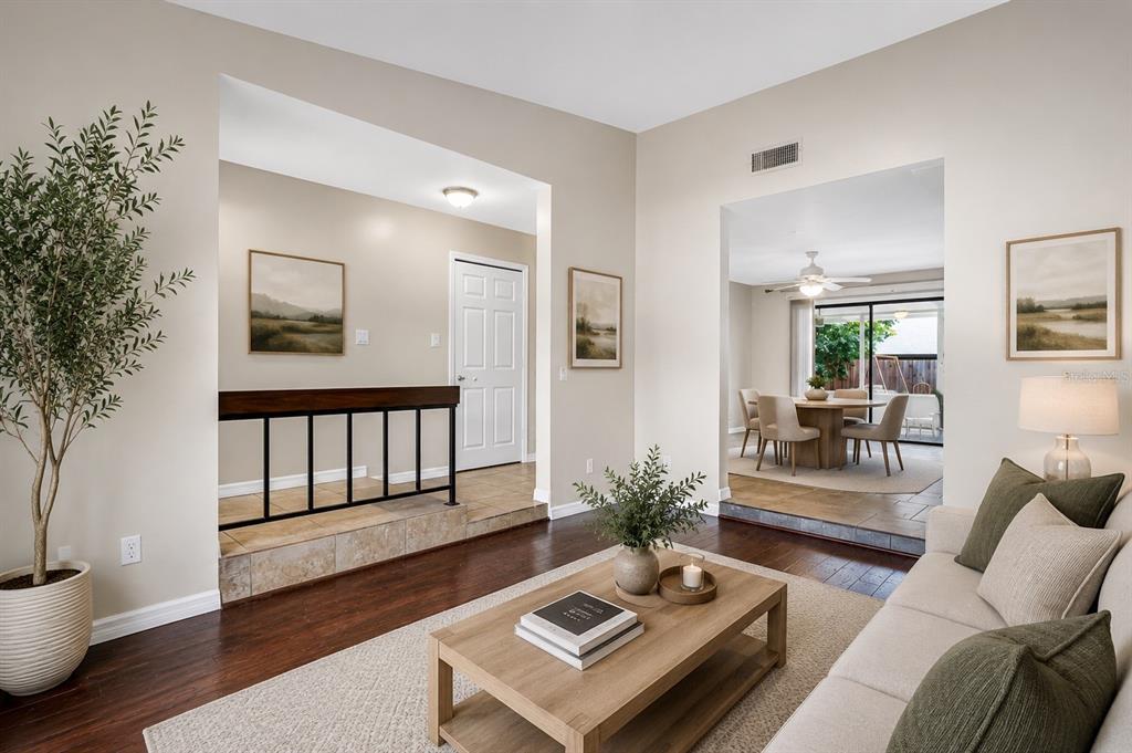 A living room with hardwood floors, a sunken dining area, and a white front door — 300 DUBLIN DRIVE, LAKE MARY, FL