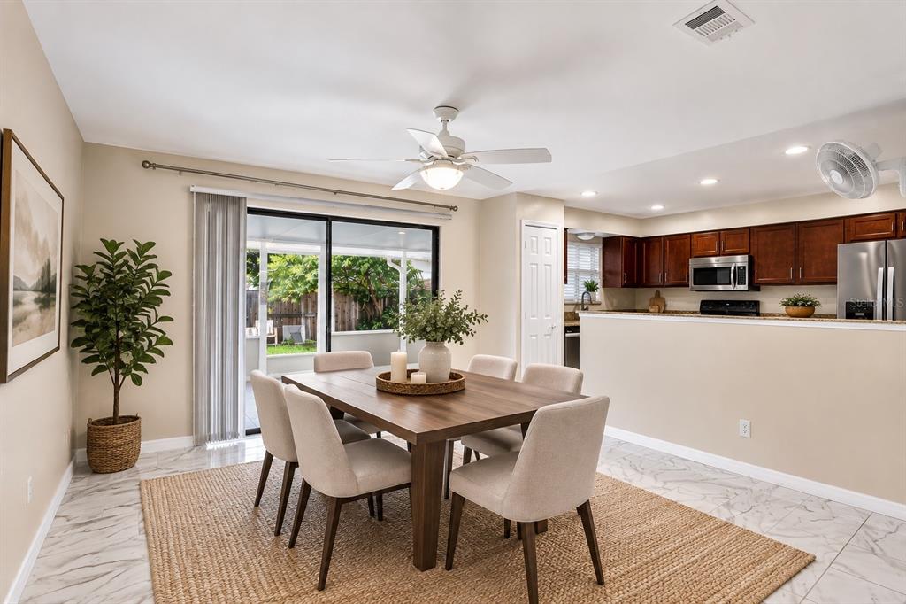 A dining area with a wooden table, six chairs, and a sliding door to a patio — 300 DUBLIN DRIVE, LAKE MARY, FL