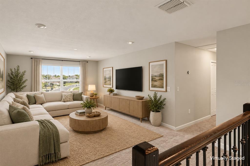 A carpeted loft area features light gray walls, recessed lighting, and a window overlooking a neighborhood — 467 BRUNSWICK DRIVE, DAVENPORT, FL
