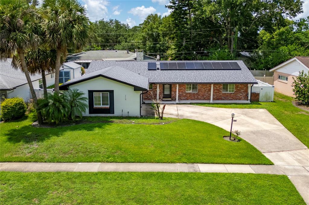 A single-story house with a brick facade, solar panels, and a concrete driveway — 2758 BANCHORY ROAD, WINTER PARK, FL