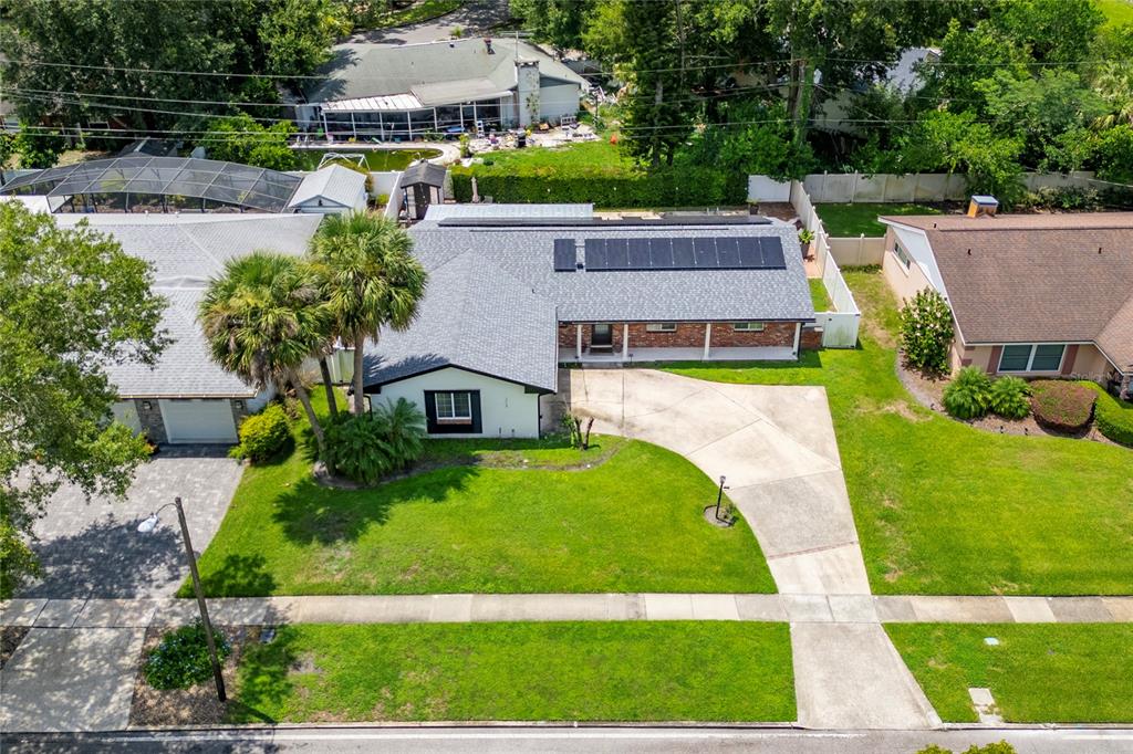An aerial view shows a single-story house with a solar panel array on the roof — 2758 BANCHORY ROAD, WINTER PARK, FL
