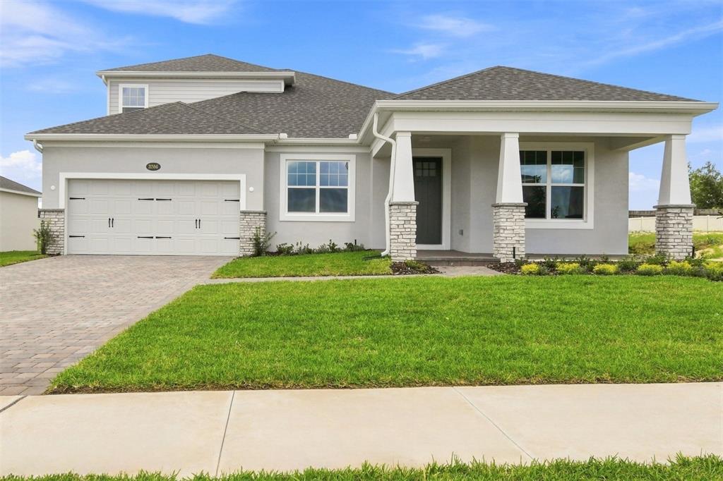 A single-story house with a two-car garage, stone-accented columns, and a covered front porch — 3206 WOLF LAKE AVENUE, APOPKA, FL