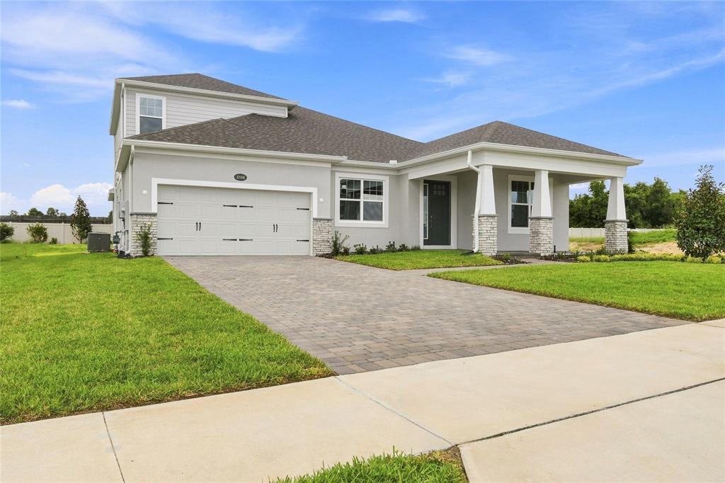 A modern kitchen features white cabinets, a large island with a sink, and stainless appliances — 3206 WOLF LAKE AVENUE, APOPKA, FL