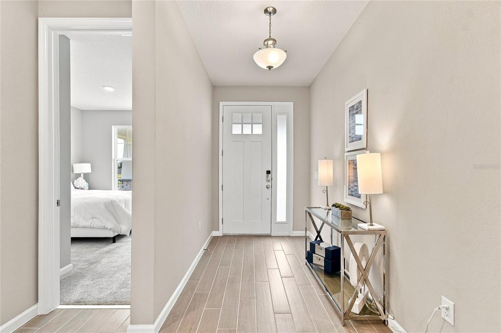 An open-concept kitchen and dining area features white cabinetry, a large island, and tile flooring — 3206 WOLF LAKE AVENUE, APOPKA, FL
