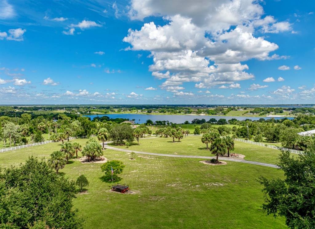A sunset view over a lake with palm trees and a grassy foreground — 664 S LAKE STARR BOULEVARD, LAKE WALES, FL