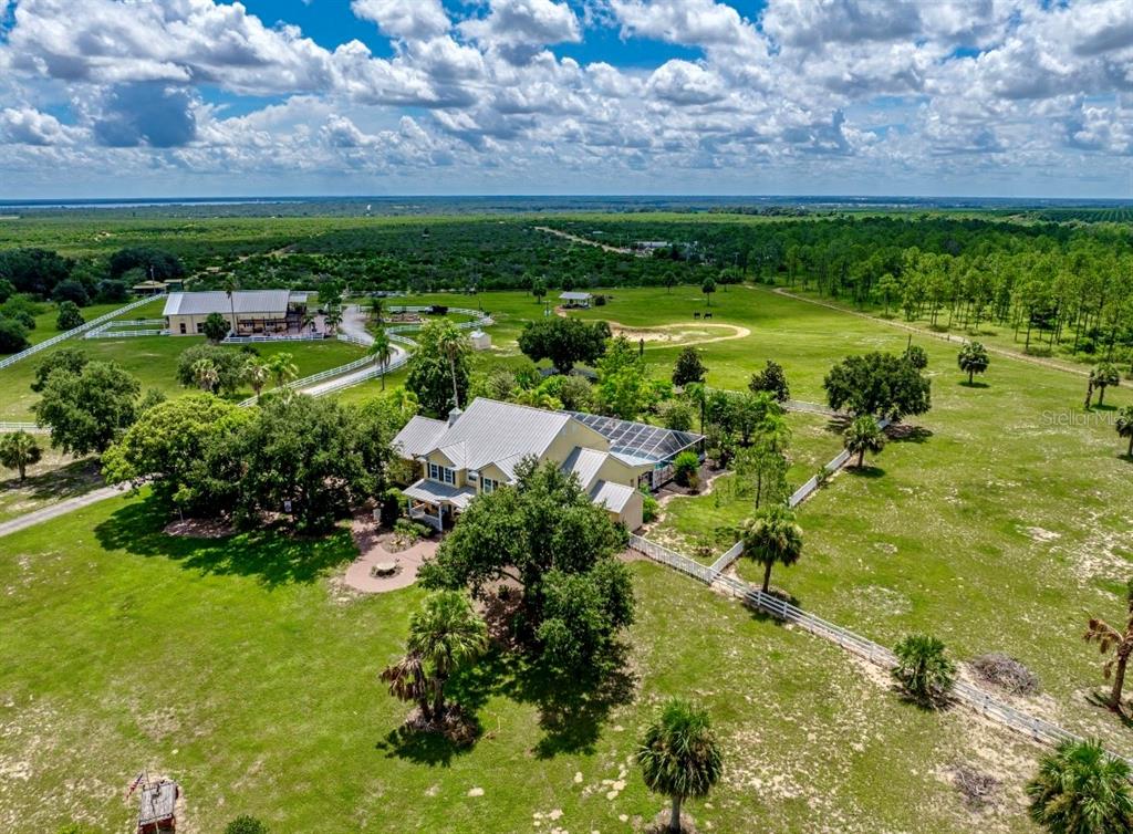 A two-story yellow house with a metal roof, front porch, and a circular fountain — 664 S LAKE STARR BOULEVARD, LAKE WALES, FL