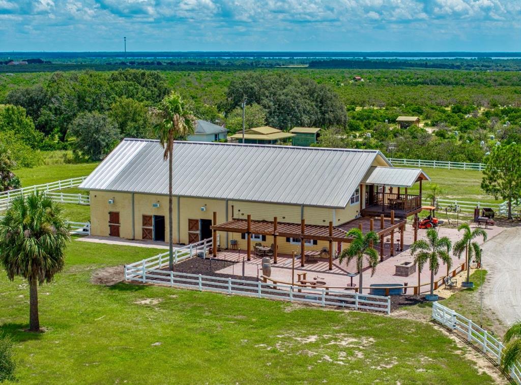 A two-story yellow house with a metal roof and a brick walkway leading to the entrance — 664 S LAKE STARR BOULEVARD, LAKE WALES, FL