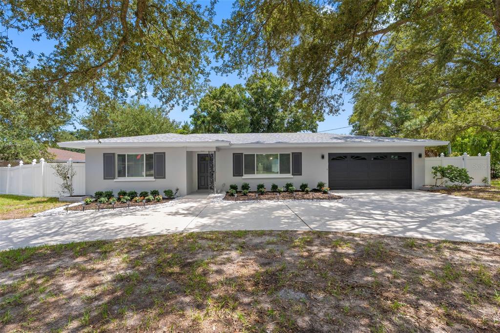 A single-story house with a gray exterior, dark shutters, and a two-car garage — 1601 HARDWOOD DRIVE, CLEARWATER, FL