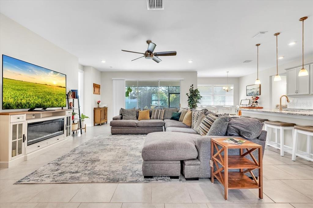 A spacious living room features a large sectional sofa, a fireplace console, and tile flooring — 2065 NUREMBERG BOULEVARD, PUNTA GORDA, FL