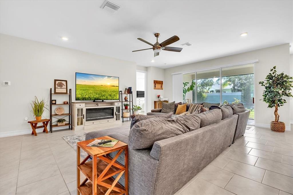 A living room features a large gray sectional sofa, a television on a console, and tile flooring — 2065 NUREMBERG BOULEVARD, PUNTA GORDA, FL