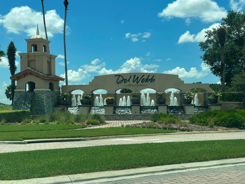 The entrance to the Del Webb Orlando community features a stone monument with cascading water fountains — 333 NAVARRA LANE, DAVENPORT, FL