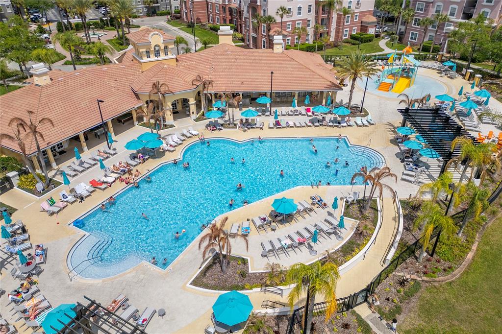 An aerial view of a large apartment complex swimming pool with lounge chairs and umbrellas — 5026 TIDEVIEW CIRCLE UNIT 17, ORLANDO, FL