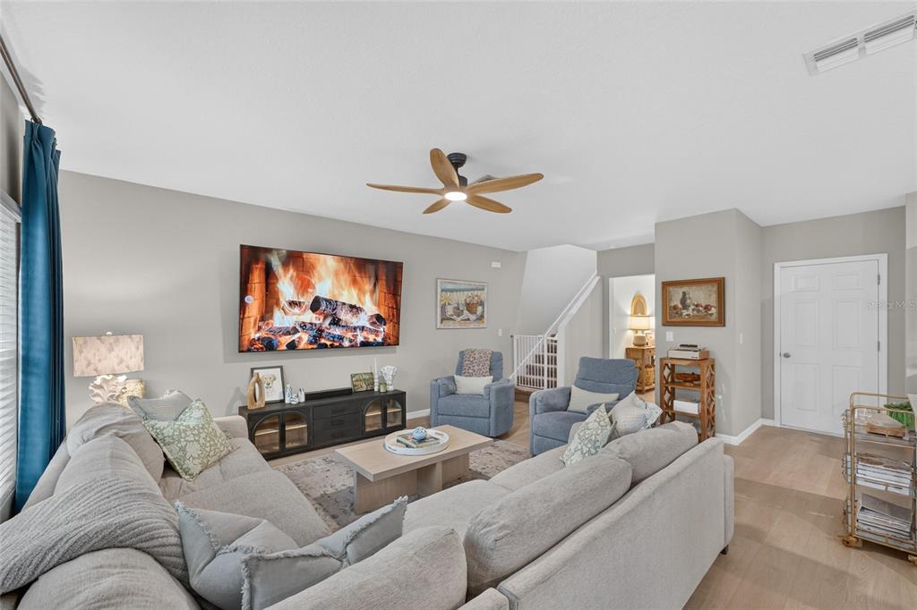 An open-concept living room and kitchen featuring a sectional sofa, dining area, and island — 7723 DEPOT LOOP, PARRISH, FL