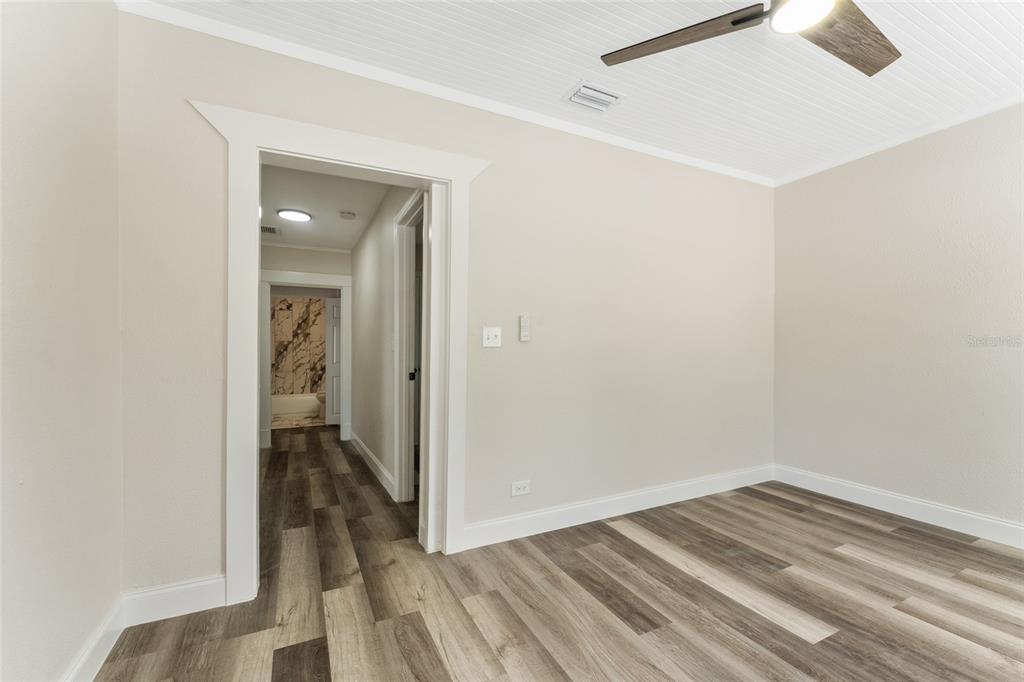 A kitchen features white cabinets, stainless steel appliances, a sink, and wood-look flooring — 1922 23RD STREET S, ST PETERSBURG, FL