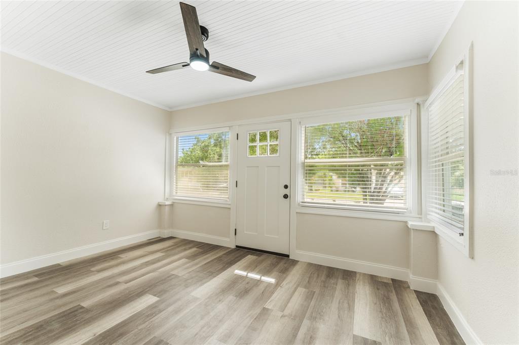 A bathroom features a white vanity, a toilet, and a bathtub with marble-patterned tile walls — 1922 23RD STREET S, ST PETERSBURG, FL