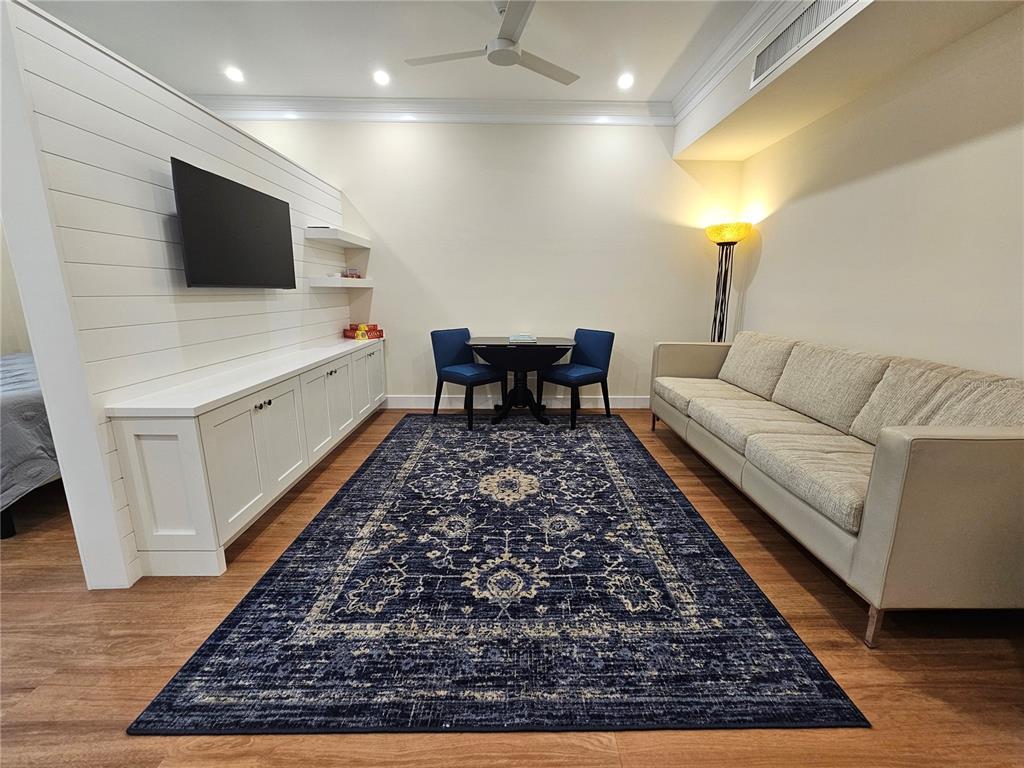 A living room features a shiplap wall with a television, a sofa, and a rug — 51 MAC EWEN DRIVE UNIT 14, OSPREY, FL