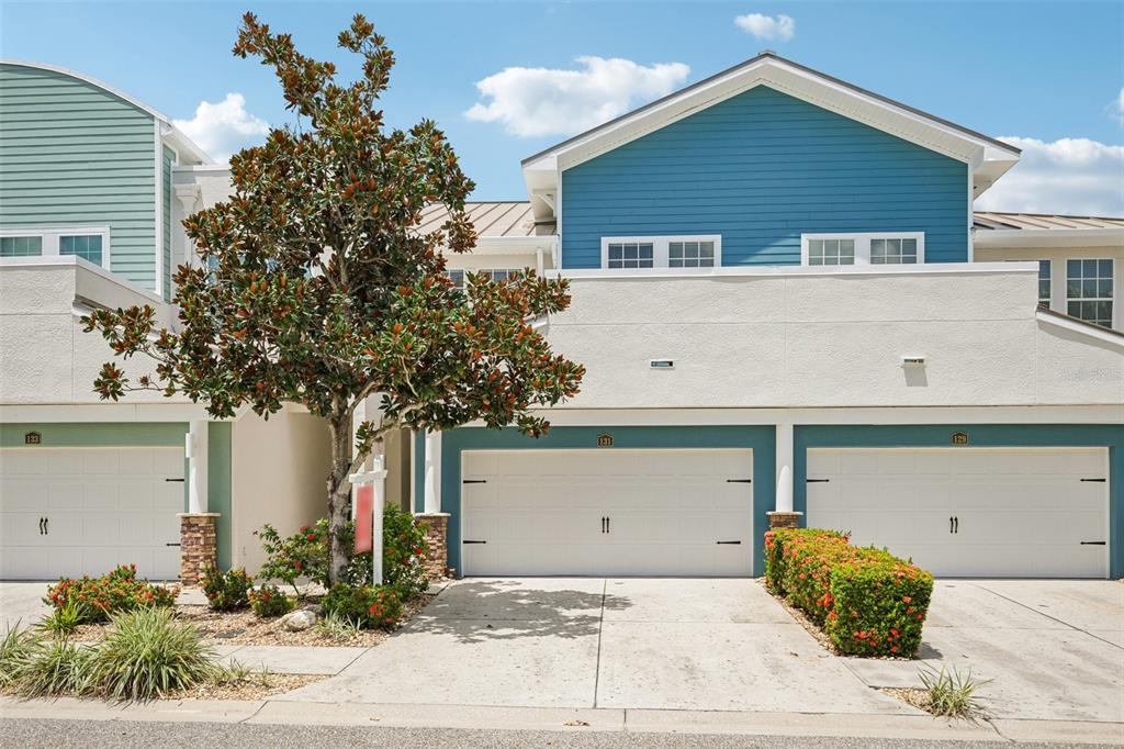 A sunken living room with a sectional sofa leads to a dining area and kitchen — 131 ATHENIAN WAY, TARPON SPRINGS, FL