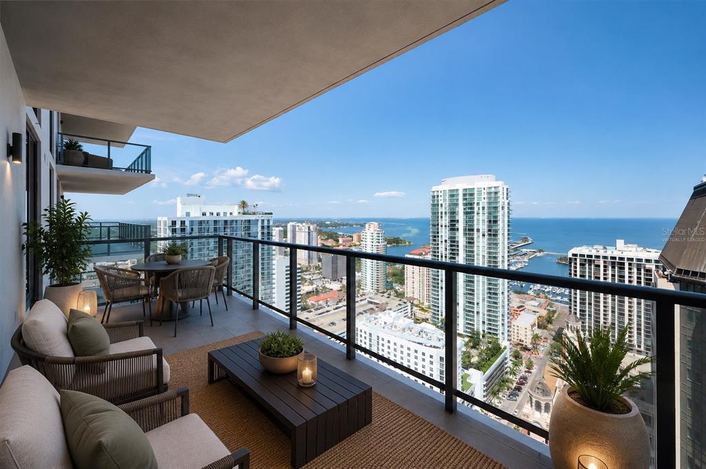 A high-rise balcony features outdoor furniture, glass railings, and a panoramic view of the ocean — 275 1ST AVENUE S UNIT 3503, ST PETERSBURG, FL