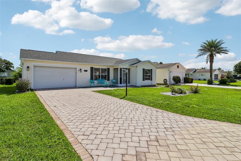 A single-story house with a paved driveway, a two-car garage, and a green lawn — 2609 PRIVADA DRIVE, THE VILLAGES, FL
